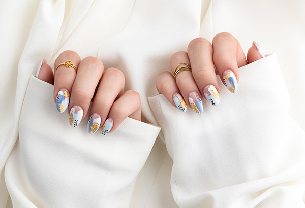 Woman's hand with fashionable nails holding fabric